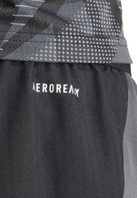 Zwarte sportshorts met gestructureerde verticale strepen, voorzien van een grijs geometrisch patroon op de elastische tailleband en een witte "AEROREADY" logo.