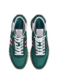 Grüne Sneakers aus Stoff und Wildleder, ausgestattet mit weißen Schnürsenkeln, mehrfarbigen Streifen und einer strukturierten Sohle mit Gummifinish.