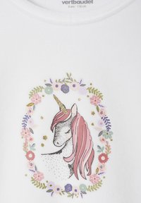 White T-shirt featuring a unicorn illustration with a pink mane, a golden horn, and floral patterns in pastel colors surrounding the design.