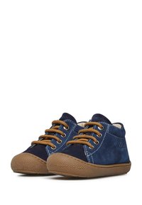 Zapatos de ante azul marino con cordones marrones, suelas de goma y costuras blancas. Diseño de punta redondeada con un forro interior suave.