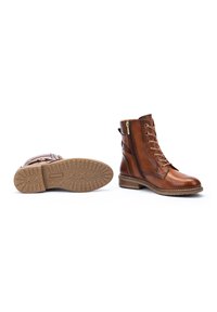 Brown leather ankle boots with laces and a side zipper. Features a textured rubber sole and stitching detail along the edges.