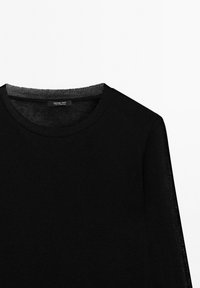 Black crew neck sweater with long sleeves, plain design, and a small label inside the neckline showing brand and origin.
