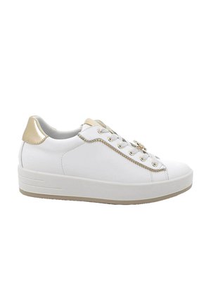 Sneaker bianca basse con suola spessa, linguetta dorata sul tallone, rifinitura dorata lungo i lacci e ciondolo decorativo dorato su sfondo bianco.