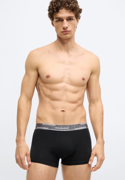 Fekete boxeralsó szürke derékpánttal, melyen az "Emporio Armani" márkajelzés látható. Az anyag sima, rugalmas és testhezálló.