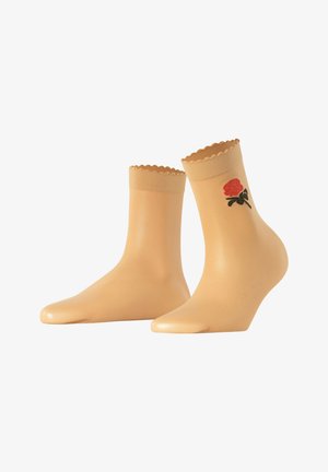 Chaussettes chevilles beiges avec des bords festonnés et des broderies de roses rouges sur le côté extérieur. Texture lisse et forme ajustée.