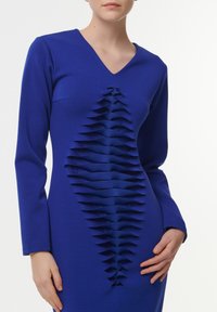 Vestido azul de manga larga con escote en V, que presenta un panel texturizado de pliegues verticales que corre por el centro. Tela suave y diseño ajustado.