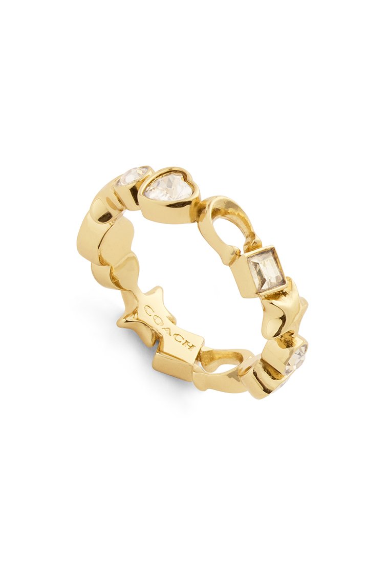 Bague en or avec des pierres claires en forme de cœur et rectangulaires alternées. L'anneau présente une texture avec une finition polie. Gravé "COACH" à l'intérieur.