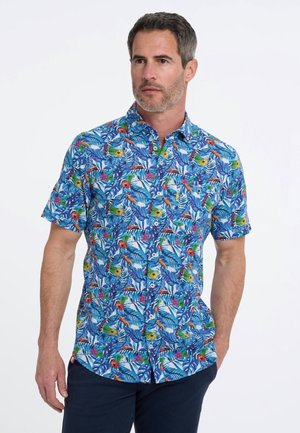 Korte mouwen shirt van blauwe stof met een levendig tropisch patroon met bladeren en bloemen in gele, rode en groene tinten.