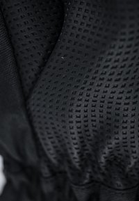 Texturiertes schwarzes Gewebe mit geometrischem Muster; verfügt über eine glatte, atmungsaktive Oberfläche mit einem gerafften Rand für eine enge Befestigung.