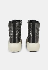 Black puffy ankle boots with a glossy finish, contrasting white sole, featuring a back pull tab and zipper detail.