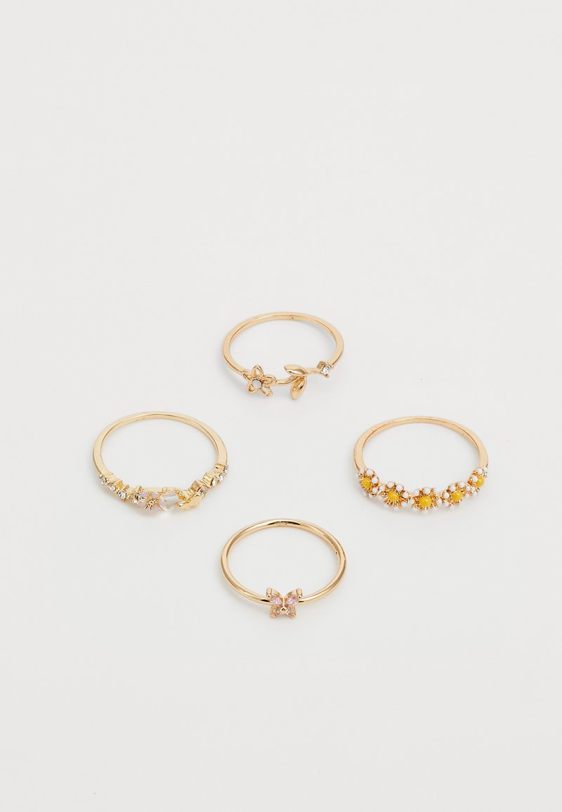 Conjunto de cuatro anillos de oro: uno con acentos florales, otro con piedras transparentes, uno con piedras amarillas y un cuarto con un detalle de piedra rosa.