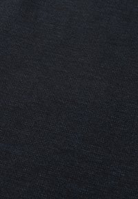 Donkerdenim stof met een gestructureerd oppervlak, voorzien van een subtiel diagonaal patroon en lichte kleurvariaties. Vloeiend en stevig materiaal.