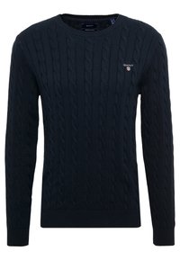 Pull en maille torsadée bleu marine avec col rond, manches longues et petit logo GANT brodé sur la poitrine gauche.