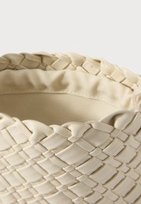 Pīta bēša mākslīgās ādas soma ar mīkstu, fakturētu virsmu. Iekšpuse sastāv no gludas auduma oderes, kas uzlabo izturību un stilu.