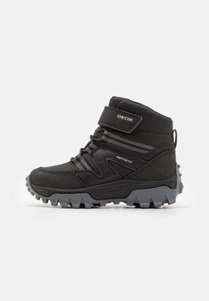 Schwarzer Geox Amphibiox Wanderschuh mit hohem Schaft, robust grauer Sohle, verstellbarem Riemen und Schnürdesign für Outdoor-Haltbarkeit.
