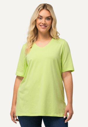 T-shirt a maniche corte con scollo a V realizzato in cotone leggero di un vivace verde lime. Design semplice con una vestibilità rilassata. Vista ravvicinata.