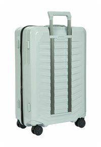 Hartschale-Koffer in Hellgrün mit vertikal gerippter Textur, ausziehbarem Griff, Doppelreißverschluss und vier schwarzen Rollen für Mobilität.