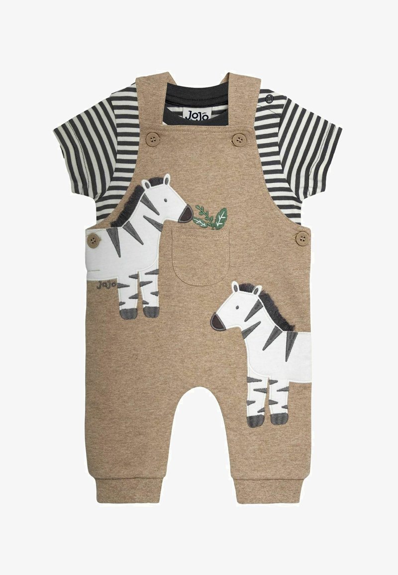 Salopette beige pour tout-petit avec appliques zèbre sur chemise à manches courtes rayée noir et blanc, avec bretelles boutonnées et une petite poche poitrine.