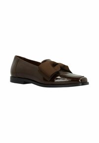 Bruine loafers van glanzend leer, met een brede bruine strik aan de voorkant en een platte, stevige zwarte zool.
