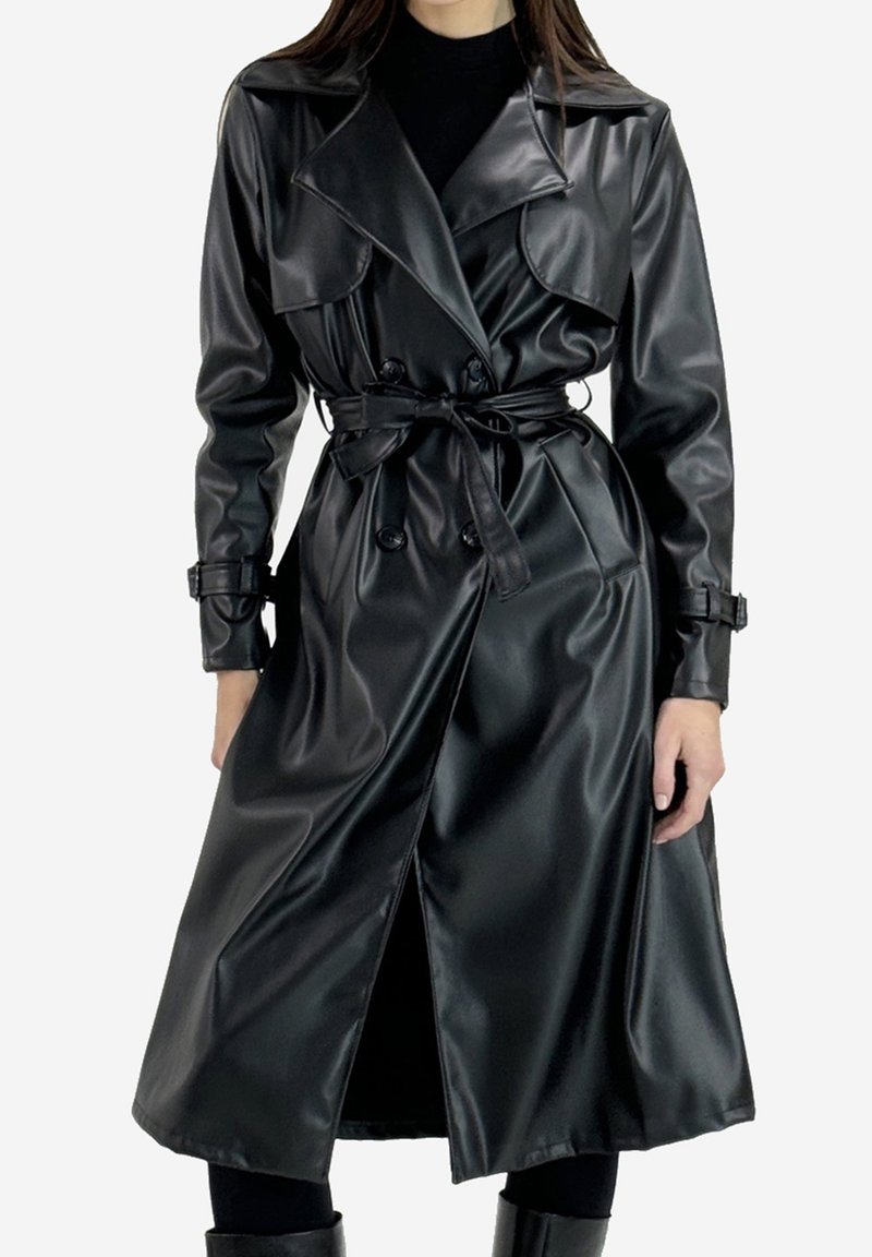 Svart trenchcoat i fusk-läder med notchad krage, knappstängning fram, skärp i midjan och sidospalt. Har långa ärmar och en blank yta.