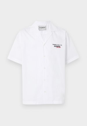 Chemise blanche à manches courtes avec col camp, texte noir et rouge "ICEBERG since 1974" sur la poitrine gauche, et étiquette de la marque à l'intérieur du col.