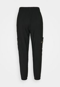 Sorte joggers med elastisk talje, smalle ben, sidelommer og en lille lynlåslomme på venstre hofte. Glat stofstruktur.