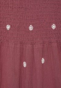 Burgundy fabric with gathered texture, featuring white embroidered flowers spaced evenly across the design, creating a subtle pattern.