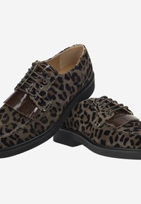 Chaussures en daim à imprimé léopard avec des accents en vernis, présentant un design à lacets, une semelle en caoutchouc noire et des détails de couture visibles.