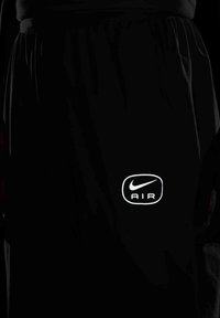 Sorte sportsshorts med et reflekterende "Nike AIR" logo på den nederste venstre side, med snoretræk i taljen og sidelommer.