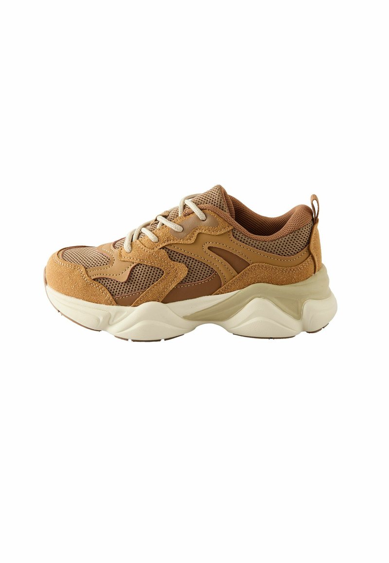 Beżowe sneakersy wykonane z siateczki i zamszu, z teksturowanym wzorem, kremową gumową podeszwą i kontrastującymi brązowymi akcentami. Posiadają zaokrąglony czubek i sznurówki.