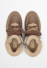 Brązowe botki za kostkę z teksturowanym kołnierzem z tkaniny, sznurowanym zapięciem oraz grubą, ryflowaną podeszwą. Wnętrze wyłożone miękkim beżowym materiałem.