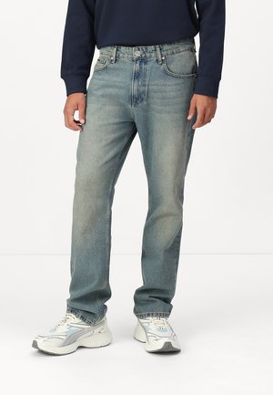 Jean en denim bleu clair, avec une coupe droite classique, un design à cinq poches et un léger délavage sur le tissu.