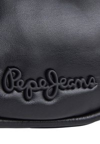 Crna kožna torba s teksturiranom površinom i istaknutim, otisnutim logotipom "Pepe Jeans" u kurzivnom stilu.