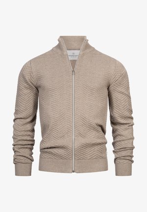 Beige vetoketjullinen neuletakki, jossa on teksturoitu sahalaitakuvio, ribbaatut hihansuut ja helma sekä korkea kaulus. Valmistettu pehmeästä neulemateriaalista.