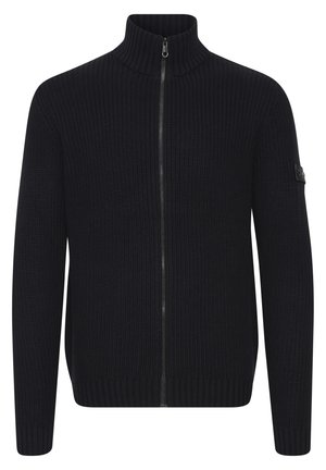 Marineblauer Strickpullover mit hohem Kragen und Reißverschluss. Rippstruktur und eng anliegende Bündchen, versehen mit einem kleinen schwarzen Logo-Detail am �Ärmel.