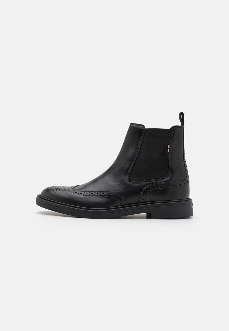 Schwarze Leder Chelsea-Boots mit Broguemuster, elastischen Seitenpanels, einem Ziehschlaufen und einer soliden schwarzen Gummisohle. Elegantes, strukturiertes Design.