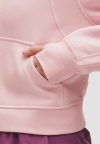 Rosa Sweatshirt aus weichem Stoff, mit einer Kängurutasche, gerippten Bündchen und glatter Textur. Sichtbare Nähdetails.