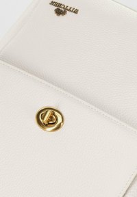 Borsa in pelle bianca con superficie testurizzata, chiusura in metallo dorato e logo del marchio impresso nella parte superiore. Design semplice e rettangolare.