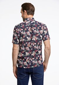 Camicia a maniche corte con sfondo blu scuro e un motivo floreale in rosso, rosa e verde. Tessuto in cotone con colletto e chiusura a bottoni.