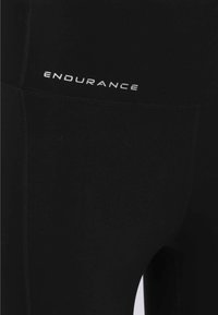 Schwarze Sportleggings aus dehnbarem Material mit hohem Bund und dem Wort "ENDURANCE" in weißer Schrift auf der Vorderseite.