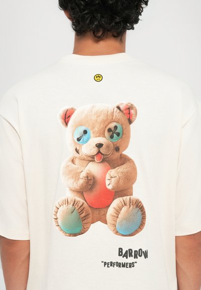 Camiseta color crema con un gráfico de un oso de peluche con ojos azules, oídos internos rojos y un vientre naranja. El texto dice "BARROW 'PERFORMERS'".