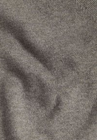 Texturovaná šedá pletenina s jemným žebrováním a různými odstíny. Měkká, flexibilní textura bez viditelných vzorů nebo kování.