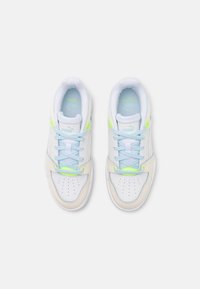 Hvite sneakers med lyseblå detaljer, med perforert tå, neon grønne elementer og lyseblå snørebånd. Teksturerte materialer og polstret krage.