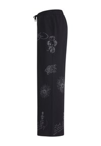 Black sweatpants with elastic waistband, featuring printed designs of a snake, tiger head, spider webs, and script text.