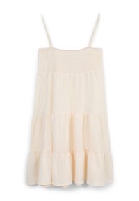 Robe d'été crème clair avec fines bretelles, corsage froncé et volants à étages à l'ourlet. Confectionnée en tissu texturé à l'aspect doux.