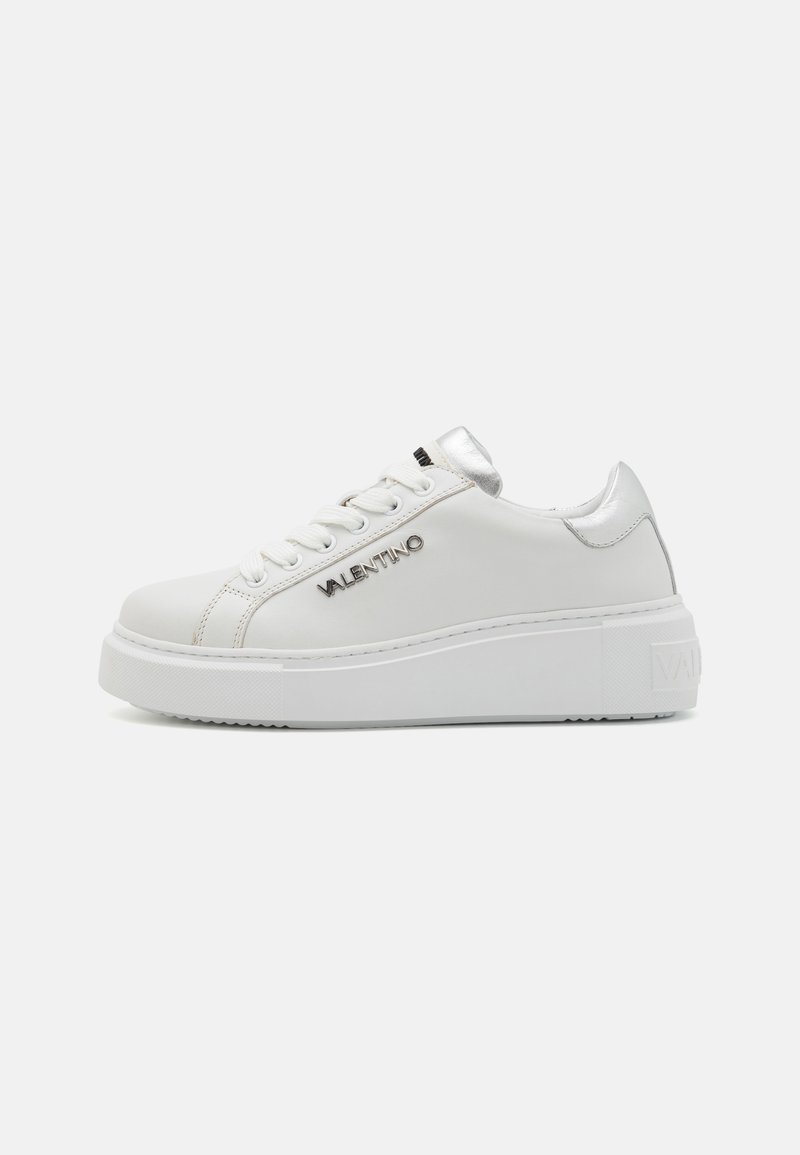 White leather sneakers with a slight platform sole, silver accents on the heel, and logo detail on the side. Smooth texture, round toe design.