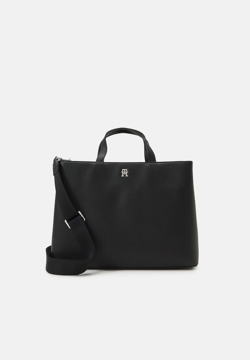 Schwarze Leder-Tote mit zwei kurzen Griffen und einem abnehmbaren Schultergurt. Hat ein silbernes Logo-Detail auf der Vorderseite.