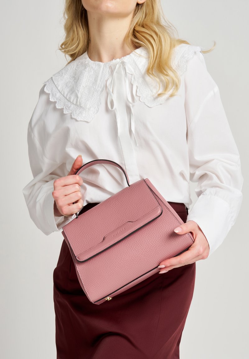 Borsa a mano in pelle rosa chiaro con forma strutturata, manico superiore e finiture nere. Presenta una superficie testurizzata e una chiusura con pattina frontale.