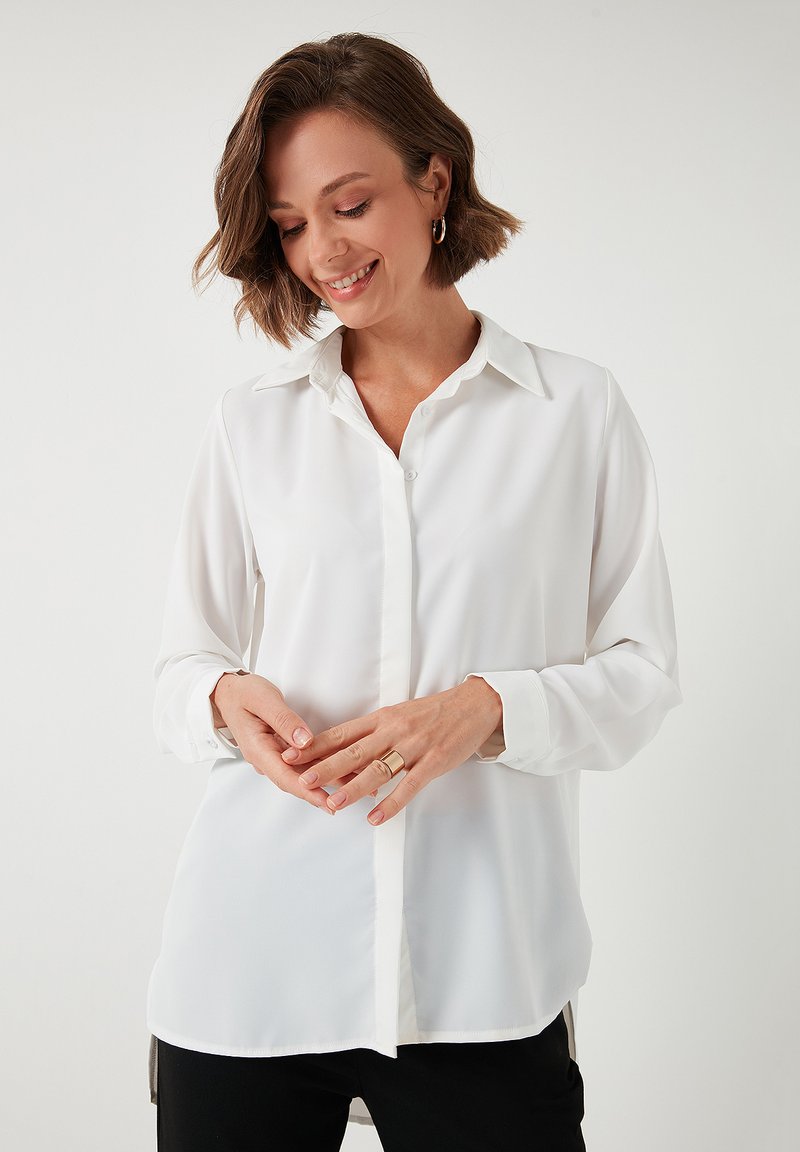 White button-up shirt made of smooth fabric, featuring a classic collar, long sleeves, and a tailored fit with a straight hem.
