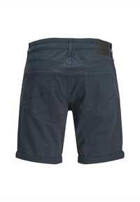 Shorts gris foncé avec ourlets retroussés, fabriqués à partir d'un tissu lisse, dotés de deux poches arrière et d'un patch en cuir de marque à la taille.